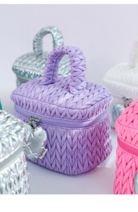 Close-up of purple quilted makeup bag with woven texture and silver heart zipper pull