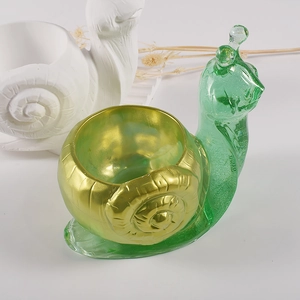 Detail of snail shaped resin container with green translucent body and spiral shell