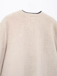 Détail du col d'un manteau en fausse fourrure beige avec texture pelucheuse premium