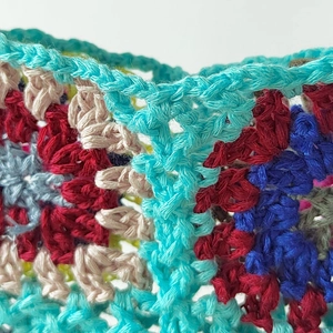 Detailed view of hand-crocheted granny square pattern in multicolor patchwork knit