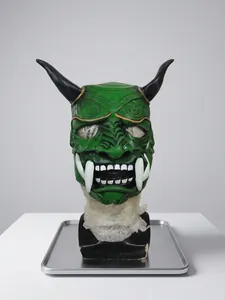Detailed close-up of green resin Hannya mask with black horns and gold cloud patterns