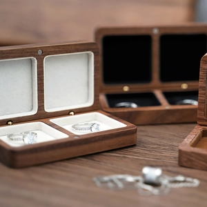 Detailed view of dark walnut double ring box with premium black and white velvet lining