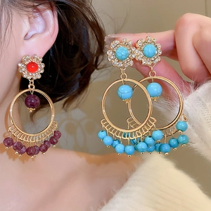 Detail of bohemian round tassel earrings with turquoise beads and sparkling rhinestones