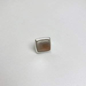 Detailed macro view of a vintage square matte silver ring with beige stone inlay