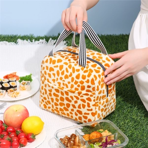 Sac à lunch isotherme motif girafe avec poignées rayées sur une couverture de pique-nique
