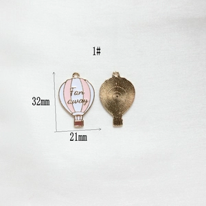 Front and back detail of 32mm pink enamel hot air balloon pendant with Far Away text