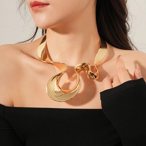 Close-up of golden irregular geometric necklace with smooth polished metallic finish