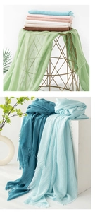 Detail of soft linen scarves in various colors with natural pleated texture and fringe edges