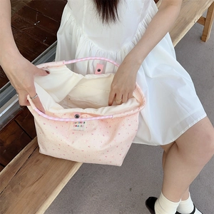 Detail of pink cartoon canvas bag with interior zipper pocket and snap button closure