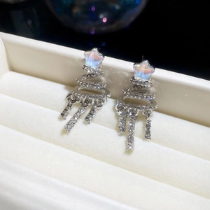 Detailed view of silver Christmas tree earrings with sparkling tassels in a jewelry box
