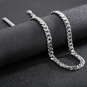 Polished silver Cuban link chain necklace on a premium black textured surface
