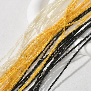 Detailed view of 2mm natural mother of pearl beads in white, yellow and black colors