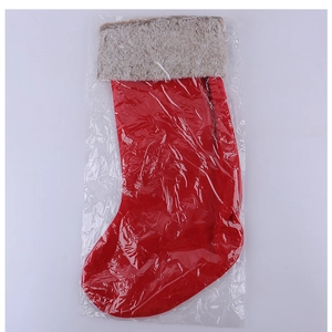 Detail of red felt Christmas stocking with plush beige cuff in transparent packaging