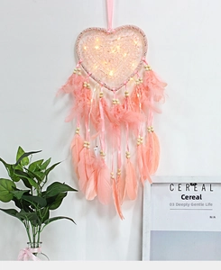 Detail of pink heart dreamcatcher with soft feathers and glowing LED fairy lights