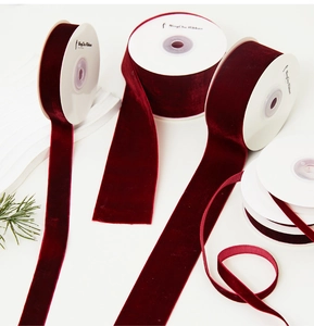 Detail of burgundy velvet ribbon rolls in various widths for luxury gift wrapping