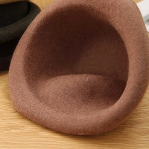Detailed texture of a brown wool felt dome hat for winter featuring a rolled brim design