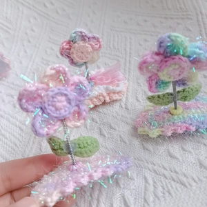 Detailed macro view of hand-crocheted puff flower hair clips with sparkling laser silk