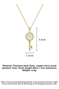 Detailed view of key pendant necklace with cat-eye stone, pave zircons and size markings