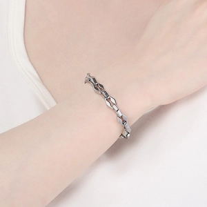 Gros plan d'un bracelet gourmette géométrique poli en acier inoxydable argenté au poignet