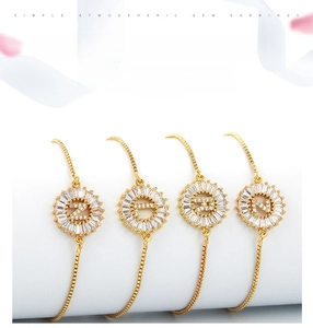 Detailed close-up of adjustable gold-plated bracelets with micro-pave zircon letter charms