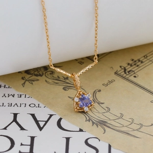 Dettaglio collana in argento S925 placcato oro 14K con gemma viola a forma triangolare