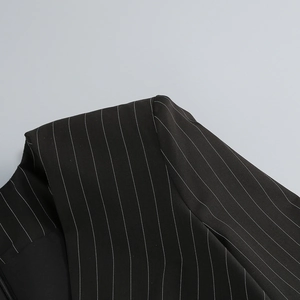 Detail of elegant black pinstripe blazer dress showing collar and shoulder stitching