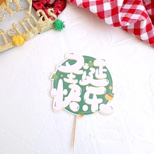 Detail of round green Merry Christmas cake topper with festive wooden pick and star motifs