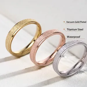 Three minimalist titanium steel rings in gold, rose gold, and silver with frosted texture