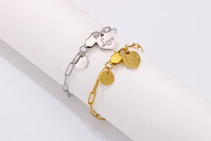 Detail of gold and silver paperclip bracelets with heart Love pendants on display