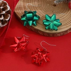 Green and red Christmas bow earrings with metallic finish on wooden base