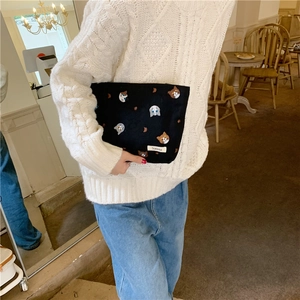 Detail of cute cat embroidery on black canvas cosmetic bag with Somikka fabric label