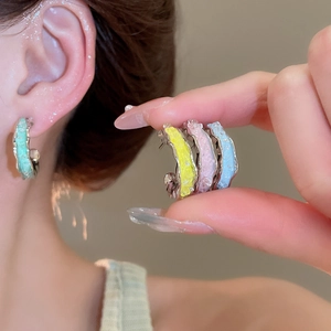 Detailansicht farbenfroher C-förmiger Kristallohrringe in Pastellgrün, Gelb, Rosa und Blau