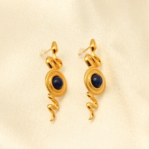 Detail of vintage snake earrings featuring gold plated coils and a dark blue lapis bead