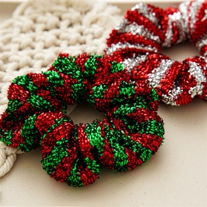 Nahaufnahme von rot-grün-silbernen Glitzer-Haargummis mit metallischer Textur für Weihnachten