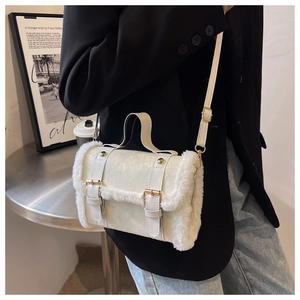 Close-up of white plush crossbody bag with gold hardware and stylish leather buckle straps