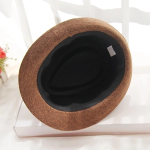 Vue détaillée de l'intérieur du chapeau de paille marron avec bandeau noir et étiquette textile