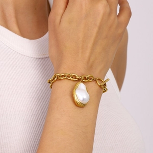 Baroque pearl pendant bracelet in 18k gold plated stainless steel on a female wrist