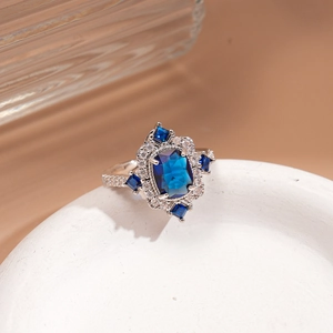Macro view of vintage silver ring with rectangular blue stone and white crystals on stone tray