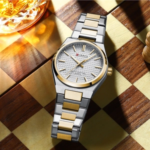 Men's two-tone quartz watch displayed on a wooden chessboard with premium business props