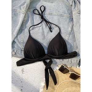 Halter neck black bikini top with pleated cups shown with beach accessories on flat lay