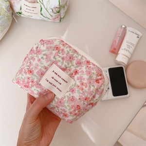 Detail of floral quilted cosmetic bag showing soft cotton texture and zipper closure