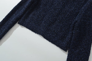 Dettaglio della maglia spessa del cardigan blu navy con texture granulosa in rilievo