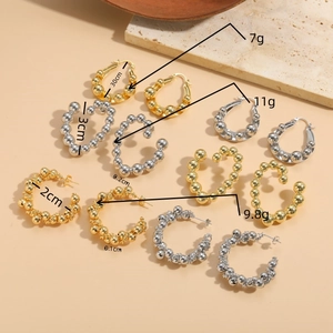 Flat lay of luxury gold and silver irregular copper bead hoop earrings in various sizes