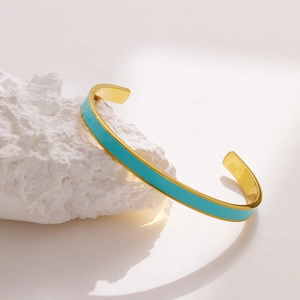 Detailaufnahme der himmelblauen Emaille-Einlage auf vergoldetem Edelstahl-C-Manschettenarmband