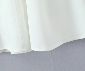 Detail of the white woven fabric hem showing precise stitching on the French vintage dress