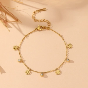 Bracelet flocon de neige en acier inoxydable doré avec cristaux sur fond pêche chaud