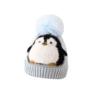 Winter knit hat for boys featuring a cute penguin pattern and a large faux fur pom-pom