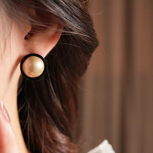 Close-up of vintage round earrings with flocking texture and gold center sphere