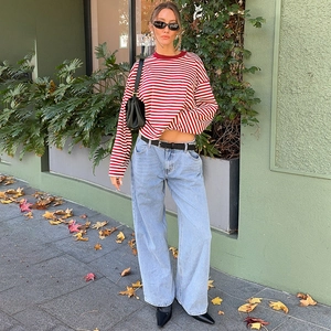 Outdoor Streetstyle von Damen Rot gestreiftes Langarmshirt und blaue Weitbein-Jeans