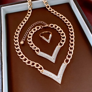 Detailed view of vintage gold chain jewelry set with V-shaped rhinestone pendants